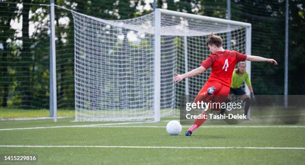 coup d’une joueuse de football déterminée donnant un coup de pied dans le ballon lors d’un match - tirer au but photos photos et images de collection