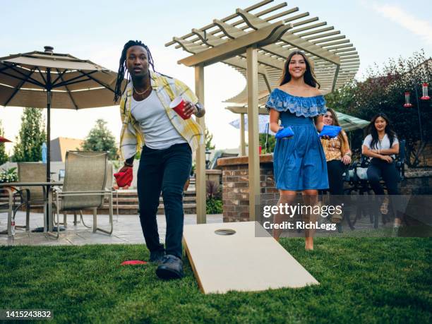 backyard party playing cornhole bean bag toss game - summer garden party bildbanksfoton och bilder