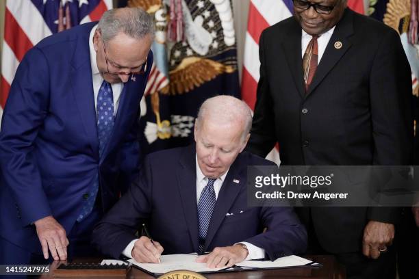 President Joe Biden signs The Inflation Reduction Act with Senate Majority Leader Charles Schumer and House Majority Whip James Clyburn in the State...