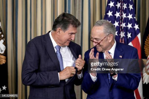 Sen. Joe Manchin looks to Senate Majority Leader Chuck Schumer after U.S. President Joe Biden signs The Inflation Reduction Act in the State Dining...