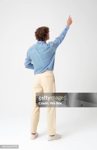 man reaching up as if interacting with a touch screen - rear view stock pictures, royalty-free photos & images
