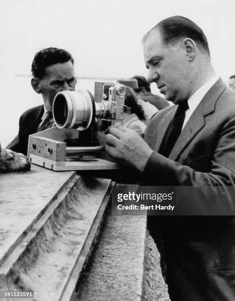 Picture Post photographer Bert Hardy with a Cinemascope anamorphic lens mounted on his Contax camera, Southend, Essex, August 1954. Original...