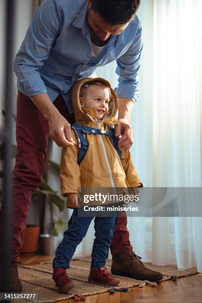 portrait of an unrecognizable man getting his daughter ready to go outside - chil morning stock pictures, royalty-free photos & images