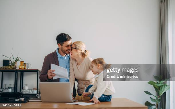 family finances: happy couple with a child looking at bills preparing to pay them online - meal expense stock pictures, royalty-free photos & images