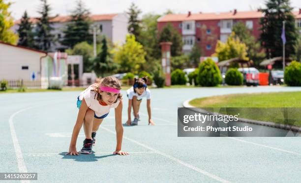 little girls preparing for run on the running track - girls on train track stock pictures, royalty-free photos & images