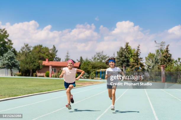 kids running a track race - stafett bildbanksfoton och bilder