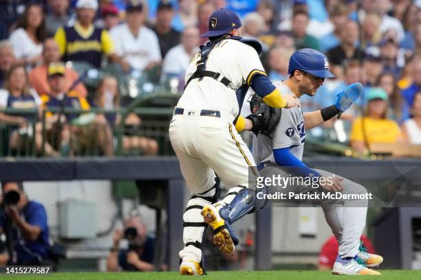 Victor Caratini of the Milwaukee Brewers tags out Trea Turner of the Los Angeles Dodgers in a run down in the first inning at American Family Field...