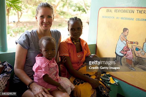 Dana Schweiger poses with a mother and her children at the Entasopia health centre on March 7, 2012 in Entasopia, in the remote southwest region of...