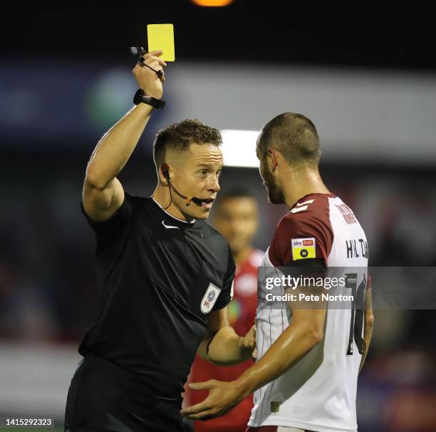 Referee Stephen Martin shows a yellow card to Danny Hylton of Northampton Town during the Sky Bet League Two between Crawley Town and Northampton...