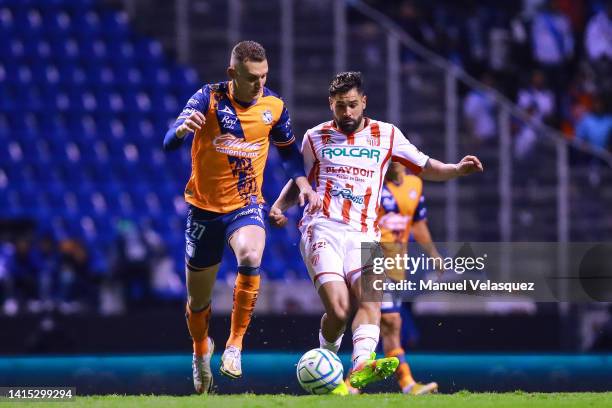 Lucas Jaques of Puebla battles for the ball against Milton Giménez of Necaxa during the 9th round match between Puebla and Necaxa as part of the...