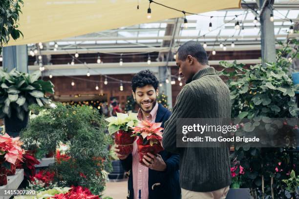 young couple choosing plants at garden center - choosing outfit stock pictures, royalty-free photos & images