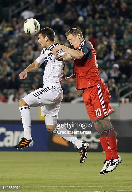 Tommy Meyer of the Los Angeles Galaxy heads the ball away from Ty Harden of Toronto FC during a CONCACAF Champions League game at The Home Depot...