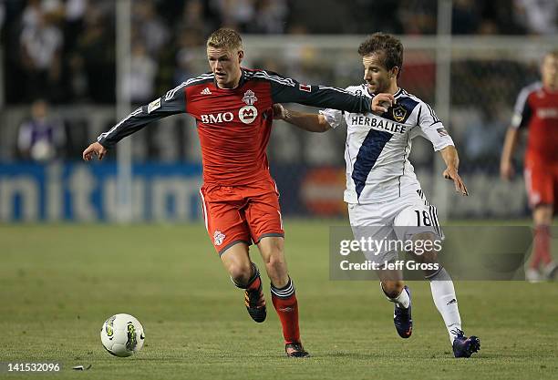 Nick Soolsma of the Toronto FC is pursued by Mike Magee of the Los Angeles Galaxy during a CONCACAF Champions League game at The Home Depot Center on...