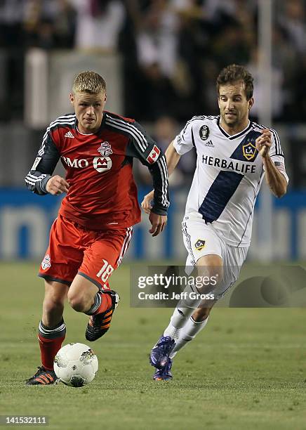 Nick Soolsma of the Toronto FC is pursued by Mike Magee of the Los Angeles Galaxy during a CONCACAF Champions League game at The Home Depot Center on...