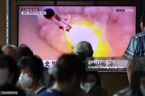 People watch a television screen showing a file image of a North Korean missile launch at the Seoul Railway Station on August 17, 2022 in Seoul,...