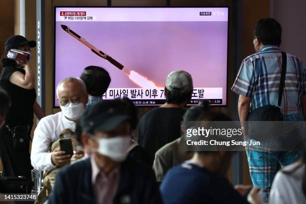 People watch a television screen showing a file image of a North Korean missile launch at the Seoul Railway Station on August 17, 2022 in Seoul,...