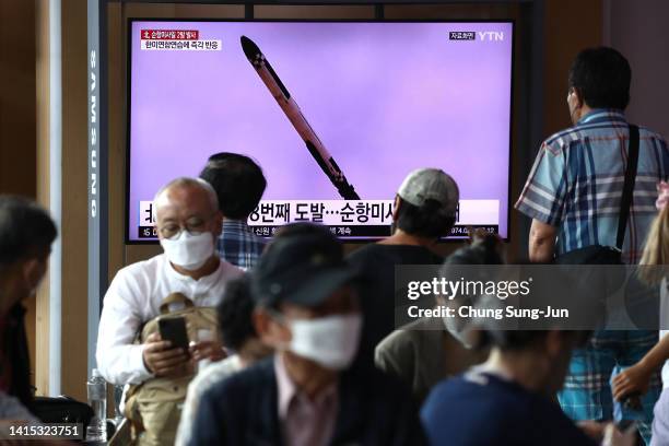 People watch a television screen showing a file image of a North Korean missile launch at the Seoul Railway Station on August 17, 2022 in Seoul,...