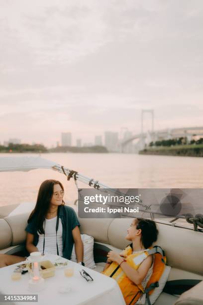 sisters enjoying boat ride at sunset in tokyo bay - eurasian ethnicity stock pictures, royalty-free photos & images