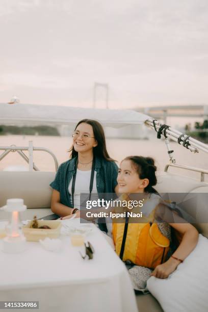 sisters enjoying boat ride at sunset in tokyo bay - eurasische herkunft stock-fotos und bilder