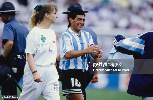 Argentine professional football player Diego Armando Maradona leaves the pitch escorted by a nurse for a routine doping check during the 1994 FIFA...