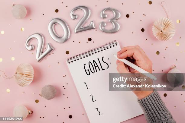 woman's hand writing goals 2023 for new year - resolução de ano novo - fotografias e filmes do acervo