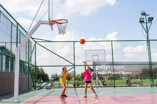 two girls playing basketball outside - girls basketball stock pictures, royalty-free photos & images