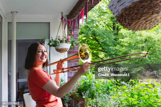 smiling girl with trombone standing on balcony - trombon bildbanksfoton och bilder