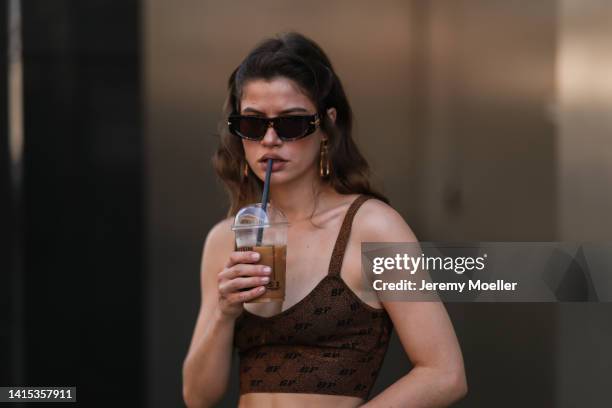 Lea Naumann seen wearing Baum & Pferdgarten brown shiny cropped bra top , Bottega Veneta brown shades and Baum & Pferdgarten x Skagen gold pendant...