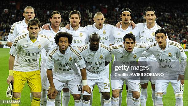 Real Madrid players wear a shirt to support Barcelona's French defender Eric Abidal, who is waiting for a liver transplant in the coming weeks, as...