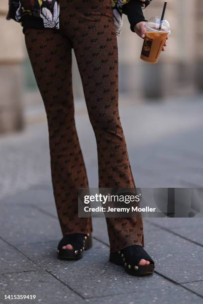 Lea Naumann seen wearing Baum & Pferdgarten brown shiny logo leggings and Ganni black wood clogs, on August 14, 2022 in Berlin, Germany.