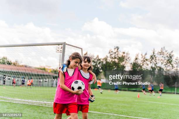 two soccer teammates walking off the field after a win - play off stock pictures, royalty-free photos & images