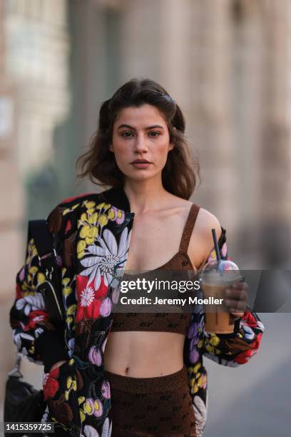 Lea Naumann seen wearing Marni colorful flower oversized statement jacket, Baum & Pferdgarten brown shiny cropped bra top and matching logo leggings,...