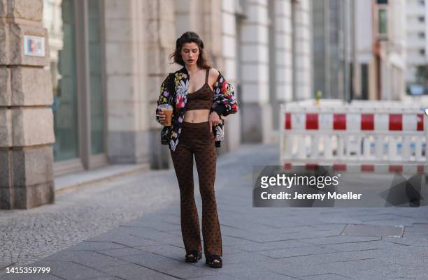 Lea Naumann seen wearing Marni colorful flower oversized statement jacket, Baum & Pferdgarten brown shiny cropped bra top and matching logo leggings,...