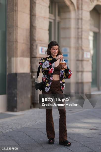 Lea Naumann seen wearing Marni colorful flower oversized statement jacket, Baum & Pferdgarten brown shiny cropped bra top and matching logo leggings,...