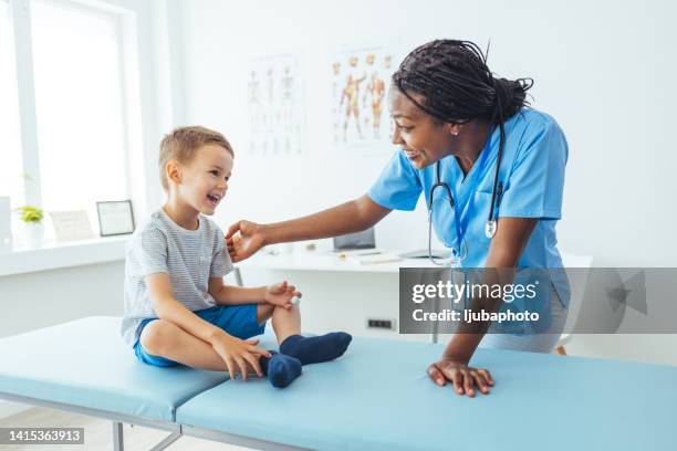 happy psychologist and little boy smiling at each other - examination table stock pictures, royalty-free photos & images