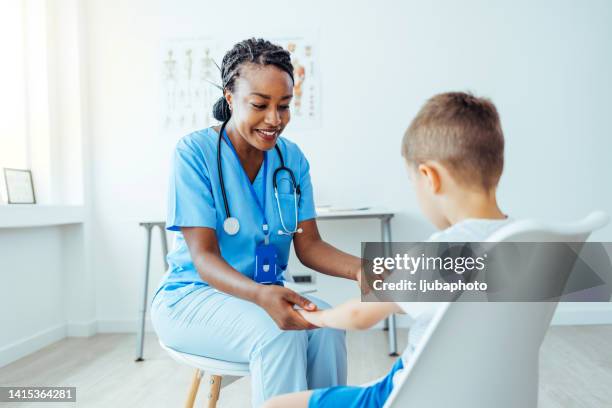 caring nurse talking to small boy - children's hospital stock pictures, royalty-free photos & images