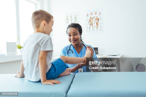 doctor is checking his muscles and bones - pediatrician bildbanksfoton och bilder
