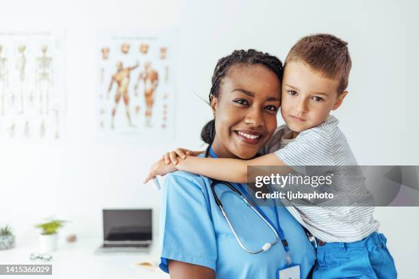 médico feliz y lindo paciente pequeño sonriendo a la cámara - cute nurses fotografías e imágenes de stock