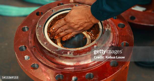 ingeniero mecánico aplicando a mano grasa, aceite metálico o lubricante para evitar daños, roturas o desgaste de maquinaria pesada. primer plano del mecánico de taller masculino que fija el equipo de fabricación de la fábrica - lubricación fotografías e imágenes de stock