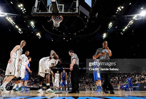 Draymond Green of the Michigan State Spartans wipes sweat off the floor late in the second half against the St. Louis Billikens during the third...