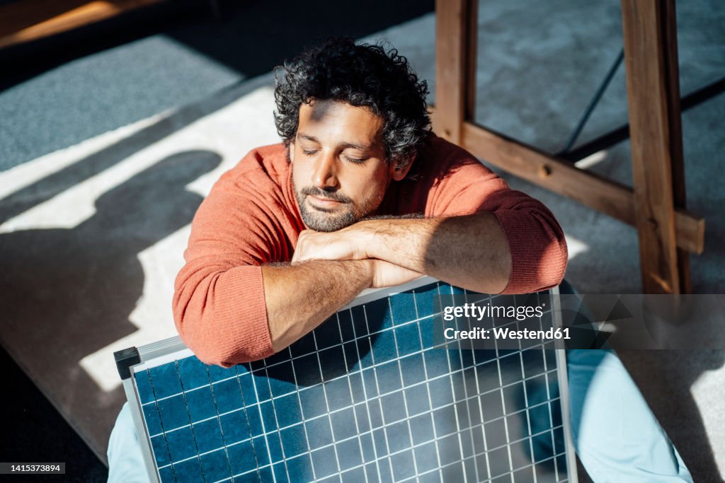 Businessman with solar panel under sunlight in office