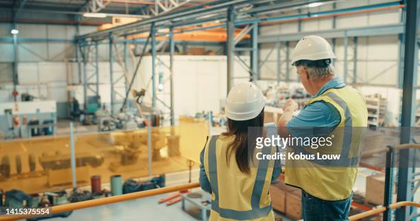 logistics workers checking stock on tablet, inspecting a factory and organising a warehouse together. male and female colleagues talking, examining a building and working in a distribution facility - storage solutions stock pictures, royalty-free photos & images