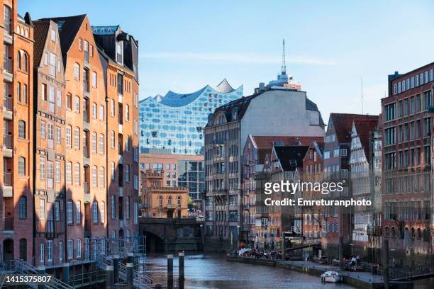canal view with old warehouses and concert hall in hamburg port. - elbphilharmonie hamburg foto e immagini stock