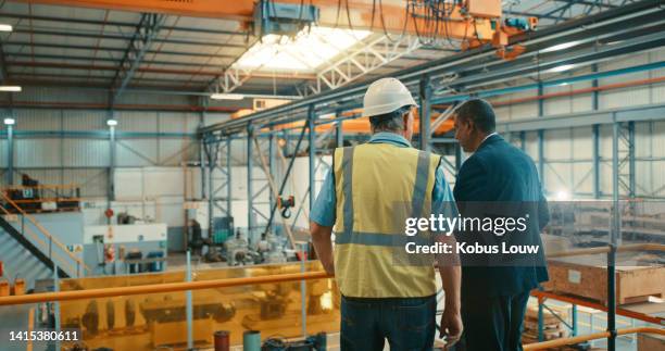 businessman and technician, manufacturing worker or engineer at a warehouse factory checking layout, planning development for business growth. back of industry manager or owner at an inspection visit - visita stock pictures, royalty-free photos & images