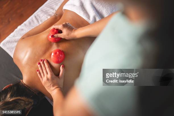 young woman enjoying at spa during back massage in a luxury spa - suction tube 個照片及圖片檔