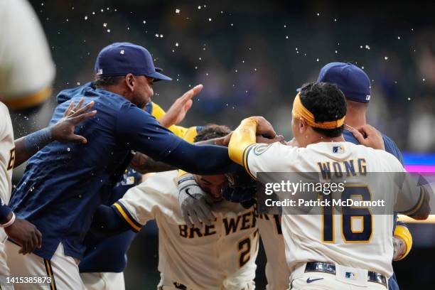 Victor Caratini of the Milwaukee Brewers celebrates with his teammates after hitting a walk-off two RBI single against the Los Angeles Dodgers in the...