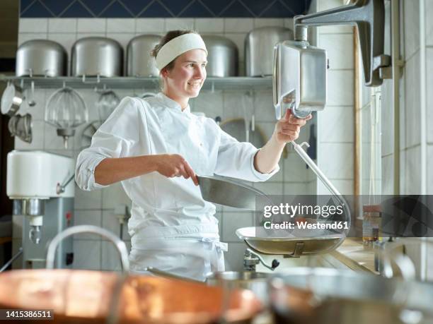 happy young confectioner measuring sugar on scale in kitchen - baby chef stock pictures, royalty-free photos & images
