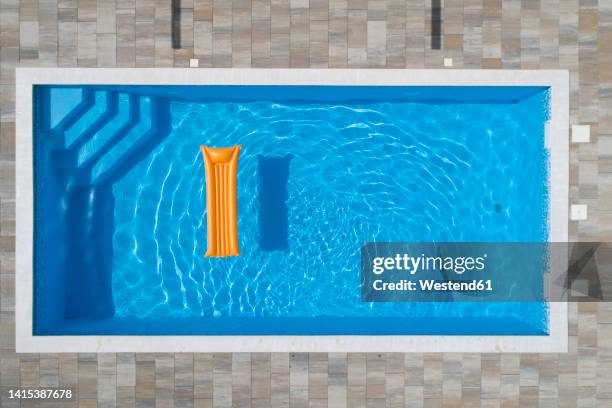 pool raft floating in swimming pool on sunny day - air bed stock pictures, royalty-free photos & images