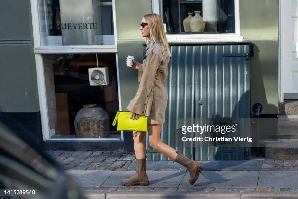 Marie Hindkaer is seen wearing yellow Copenhagen Studios clutch, brown Copenhagen Studios boots, beige jacket on August 11, 2022 in Copenhagen,...
