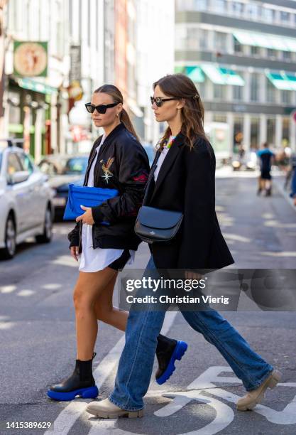 Mathilde Ravn is seen wearing blue Copenhagen Studios bag, black blue Copenhagen Studios boots, black bomber jacket with print, shorts, white button...